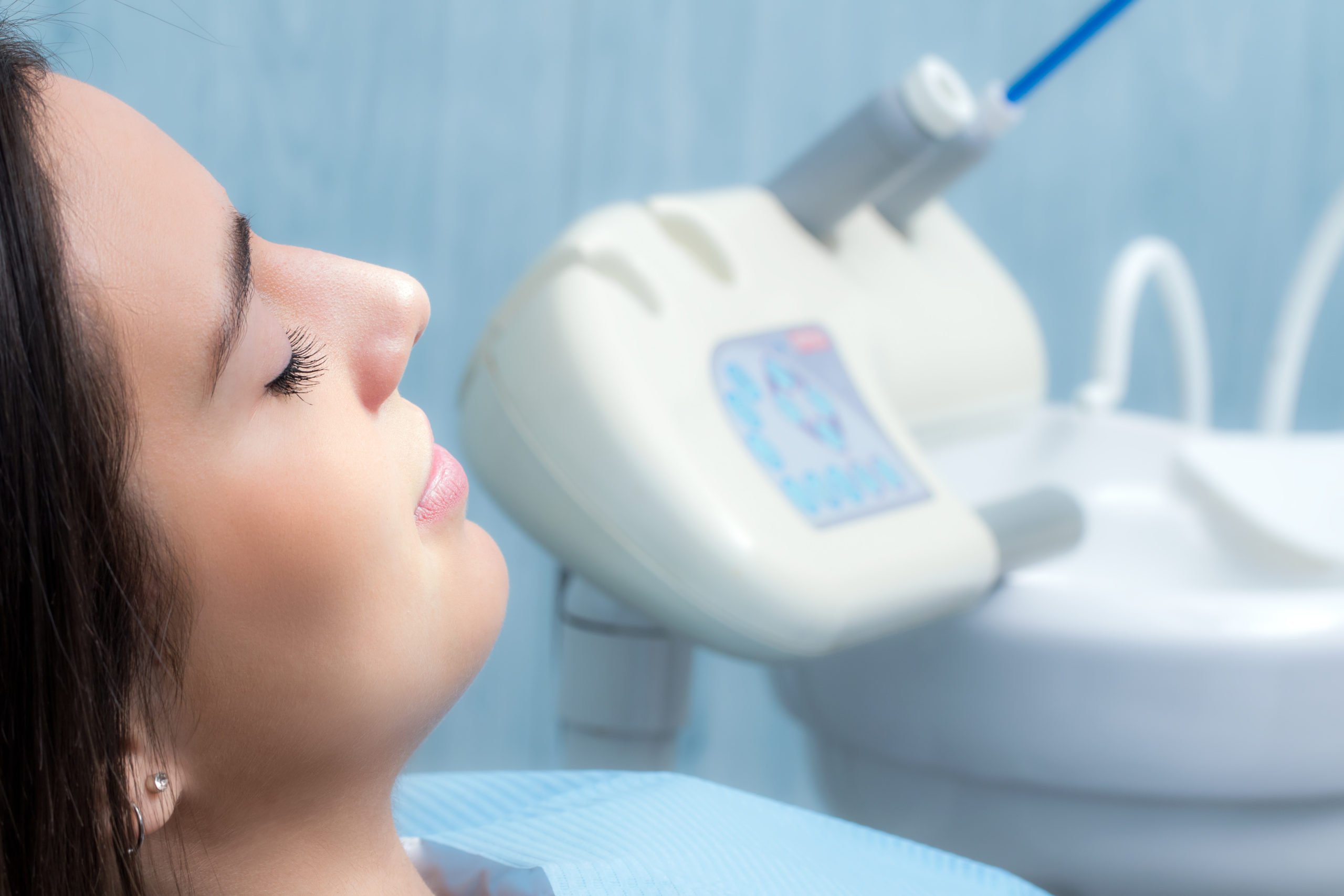 Woman in a dental implant clinic, receiving a consultation from a dental professional in a modern, well-equipped dental office, highlighting personalized care and attention.